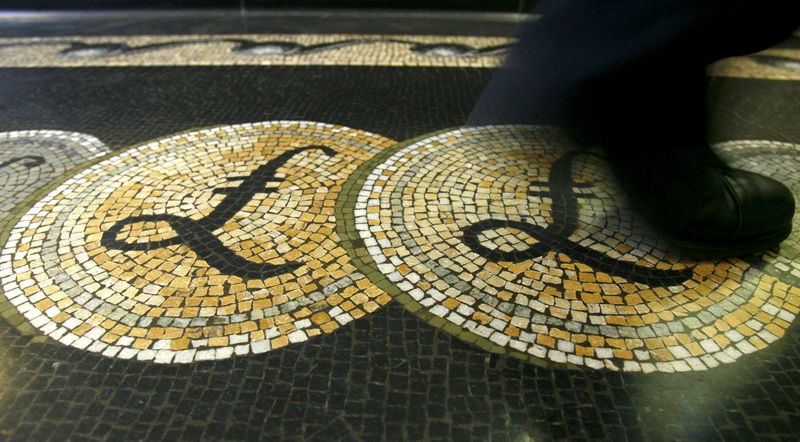 &copy; Reuters. FILE PHOTO: An employee is seen walking over a mosaic of pound sterling symbols set in the floor of the front hall of the Bank of England in London, in this March 25, 2008 file photograph. REUTERS/Luke Macgregor