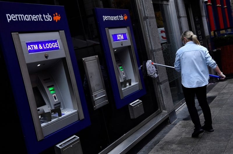 &copy; Reuters. FILE PHOTO: A worker wearing a protective face mask mops a Permanent TSB bank ATM, as the spread of the coronavirus disease (COVID-19) continues in Dublin, Ireland, November 30, 2021. REUTERS/Clodagh Kilcoyne