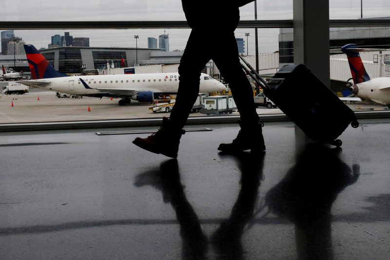 &copy; Reuters. FILE PHOTO: A passenger walks past a Delta Airlines plane at a gate at Logan International Airport in Boston, Massachusetts, U.S., January 3, 2022. REUTERS/Brian Snyder/File Photo