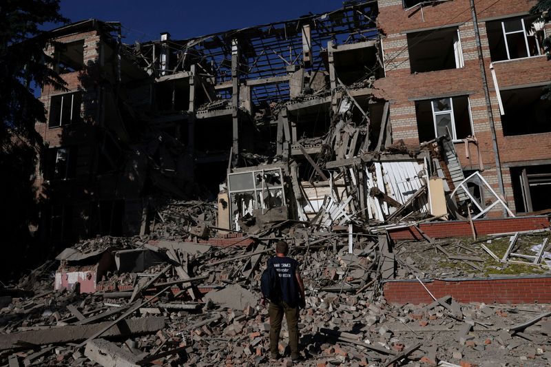 &copy; Reuters. أحد العاملين من مكتب الادعاء في جرائم الحرب يقف على حجم الأضرار التي لحقت بأحد المباني في خاركيف على إثر قصف استهدف المدينة يوم 21 من يونيو حز