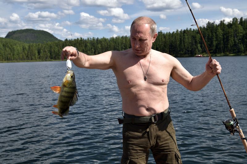 &copy; Reuters. الرئيس الروسي فلاديمير بوتين يحمل سمكة اصطادها خلال رحلة صيد في جنوب سيبيريا عام 2017. صورة من الكرملين من أرشيف رويترز 