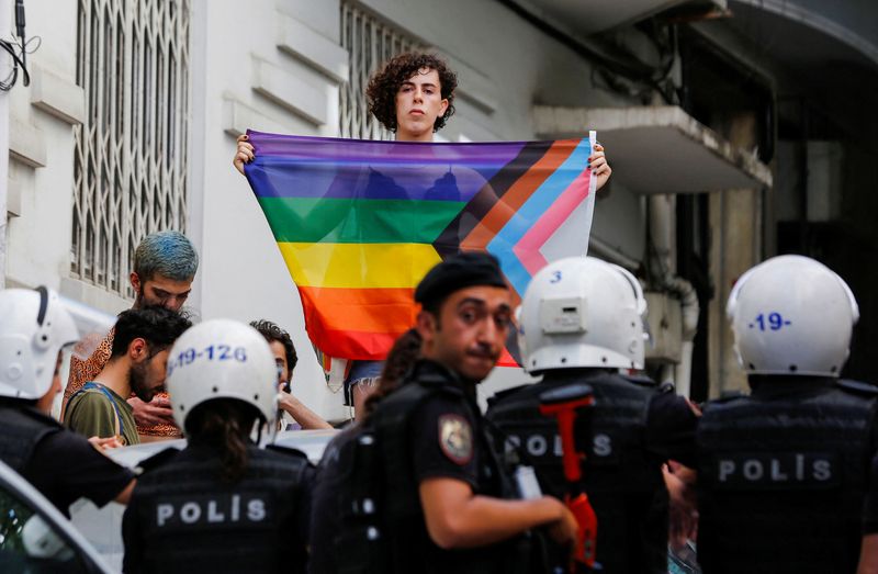 &copy; Reuters. متظاهرة ترفع علم قوس قزح أمام أفراد الشرطة خلال مسيرة في وسط إسطنبول منعتها السلطات التركية يوم الأحد. تصوير: ديلارا سينكايا - رويترز