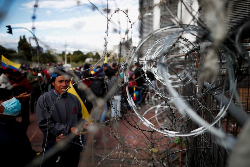 &copy; Reuters. Demonstrators look at a barricade covered in barbed wire as protests continue amid a stalemate between the government of President Guillermo Lasso and largely indigenous demonstrators who demand an end to emergency measures, in Quito, Ecuador June 26, 202