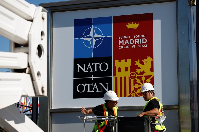&copy; Reuters. Varios trabajadores cuelgan los carteles que anuncian la celebración de la cumbre de la OTAN en Madrid, España. 27 junio 2022. REUTERS/Juan Medina
