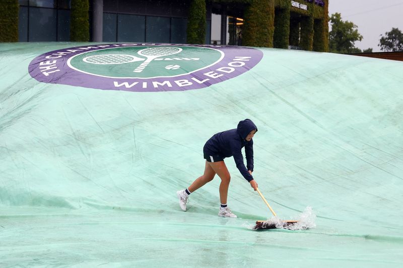 &copy; Reuters. Funcionários retiram água de cobertura das quadras externas de Wimbledon
27/06/2022 REUTERS/Hannah Mckay