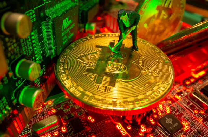 &copy; Reuters. FILE PHOTO: A small toy figure and representations of the virtual currency bitcoin stand on a motherboard in this picture illustration taken May 20, 2021. REUTERS/Dado Ruvic/Illustration/File Photo