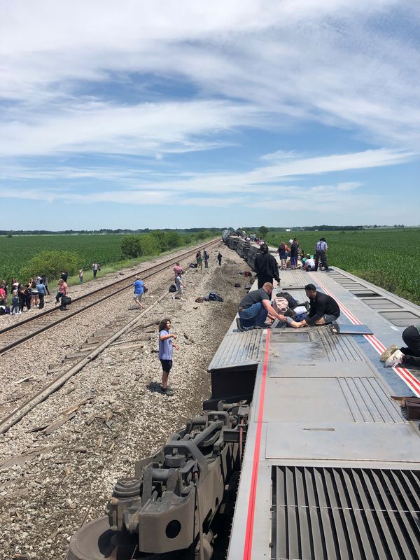 © Reuters. 　米中西部ミズーリ州北部で２７日、全米鉄道旅客公社（アムトラック）の列車が踏切でダンプカーと衝突して脱線し、当局によると列車に乗車していた２人とダンプカーに乗っていた１人の計３人が死亡し、少なくとも５０人が負傷した。写真は脱線した車両から脱出する乗客。２７日撮影。Dax McDonald氏提供（２０２２年　ロイター）