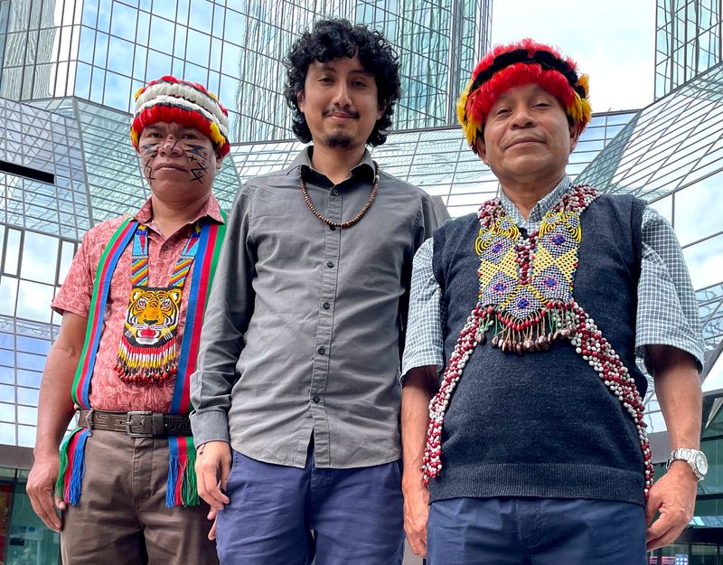 © Reuters. Ankuash Mitiap Kapuchak and Shapiom Noningo Sesen, indigenous leaders from Peru and Ricardo Perez of the environmental activist group Amazon Watch pose in front of Deutsche Bank headquarters in Frankfurt, Germany, June 27, 2022. Picture taken June 27, 2022.    REUTERS/Tom Sims