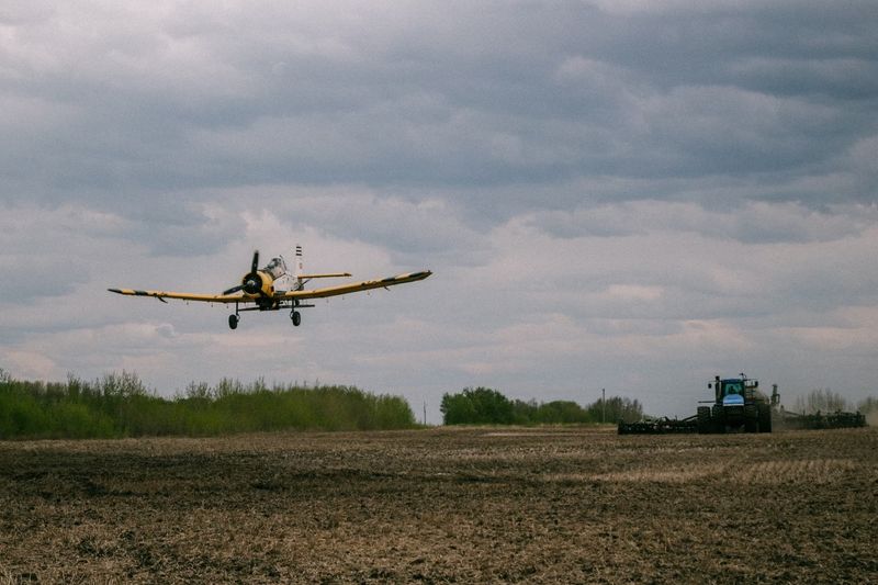 &copy; Reuters. John Lepp seeds wet spots in a field with canola by airplane, while daughter Cassandra Lepp plants the crop with a tractor, near Rivers, Manitoba, Canada May 27, 2022. Picutre taken May 27, 2022. Stefanie Lepp/Handout via REUTERS    