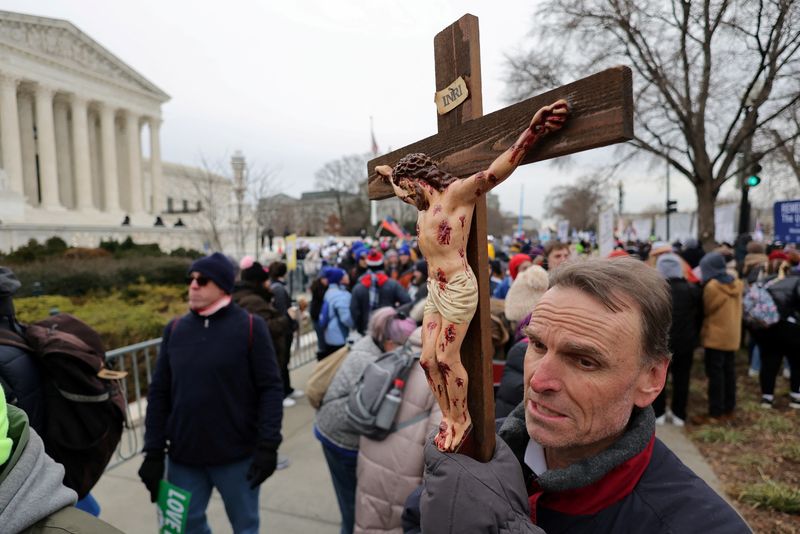 &copy; Reuters. FILE PHOTO: An anti-abortion activist holding a cross prays in front of the U.S. Supreme Court building during the annual "March for Life", in Washington, U.S., January 21, 2022. REUTERS/Jim Bourg/File Photo