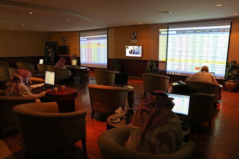 &copy; Reuters. متعاملون يراقبون شاشة تعرض أسعار الأسهم في البورصة السعودية بالرياض في صورة من أرشيف رويترز.
