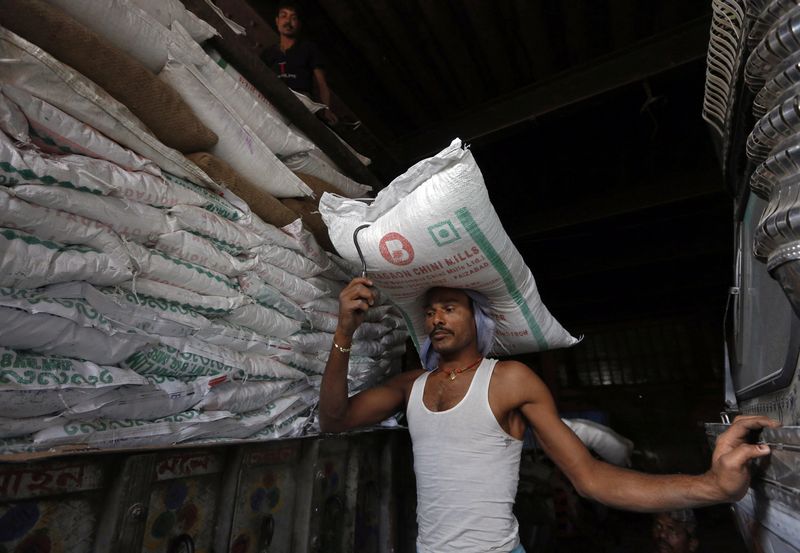 © Reuters. FILE PHOTO: A labourer carries a sack of sugar to load it onto a supply truck at a market area in Kolkata, India, January 25, 2019. REUTRS/Rupak De Chowdhuri