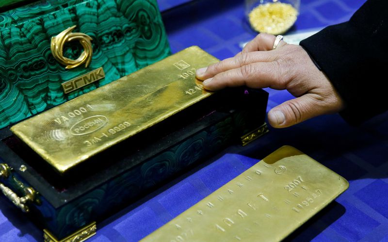 © Reuters. FILE PHOTO: An employee displays a gold bar at a gold refining workshop of the plant of Uralelektromed Joint Stock Company (JSC), the enterprise of Ural Mining and Metallurgical company (UMMC) in the town of Verkhnyaya Pyshma, outside Yekaterinburg, October 17, 2014. REUTERS/Maxim Shemetov/File Photo