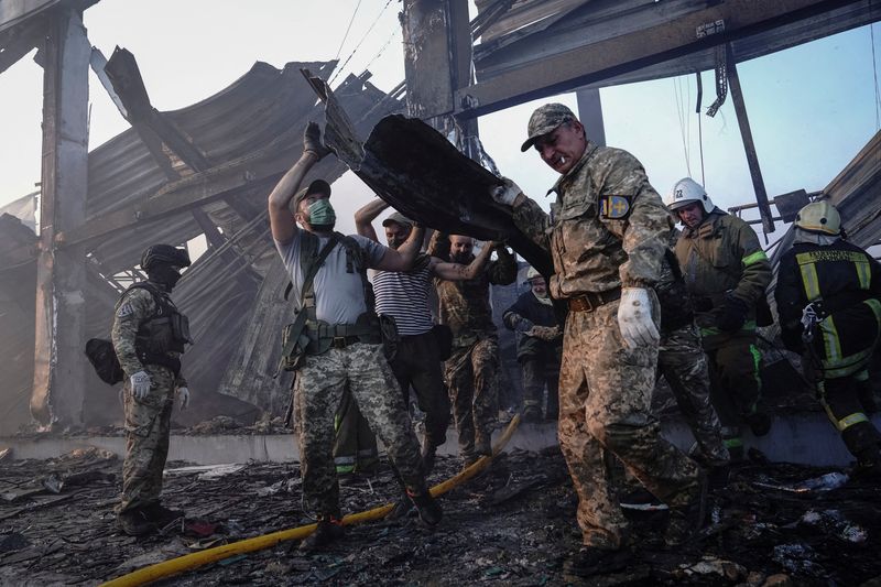 &copy; Reuters. ロシアのミサイル攻撃を受けたウクライナ中部ポルタワ州クレメンチュクのショッピングセンターでは２８日も消防士による生存者の捜索・救助活動が行われた。２７日撮影（２０２２年　