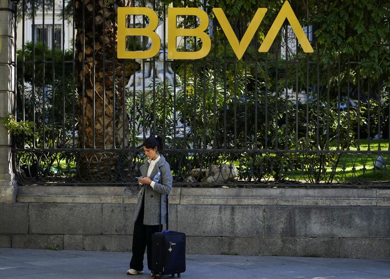 &copy; Reuters. FILE PHOTO: A woman scans through her phone outside a BBVA bank building in Madrid, Spain, November 15, 2021. REUTERS/Juan Medina
