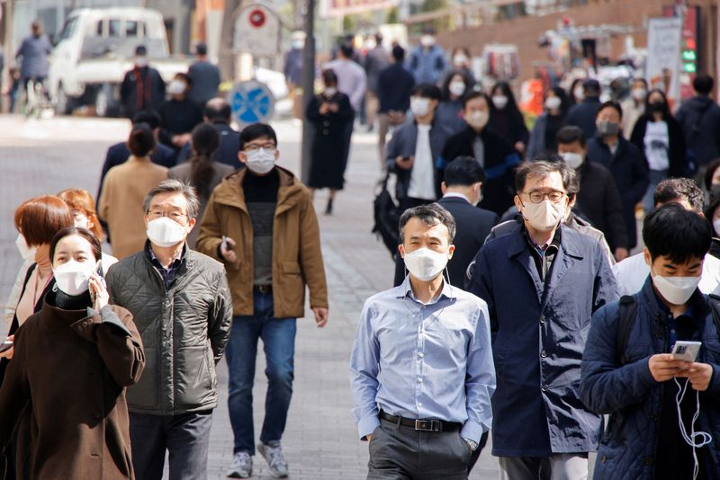 &copy; Reuters. People wearing masks walk in a shopping district amid the coronavirus disease (COVID-19) pandemic in Seoul, South Korea, March 16, 2022. REUTERS/Heo Ran