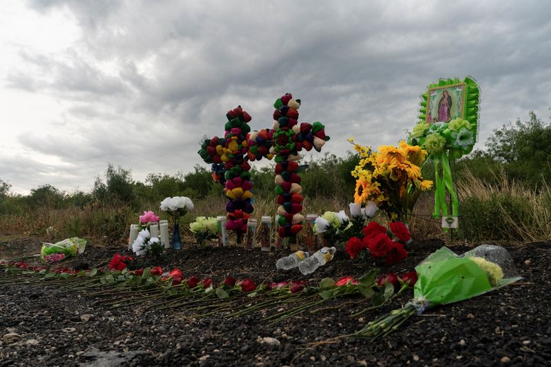 © Reuters. Flowers, candles, and water bottles are placed at the scene where dozens of migrants were found dead inside a trailer truck in San Antonio, Texas, U.S. June 28, 2022. REUTERS/Go Nakamura