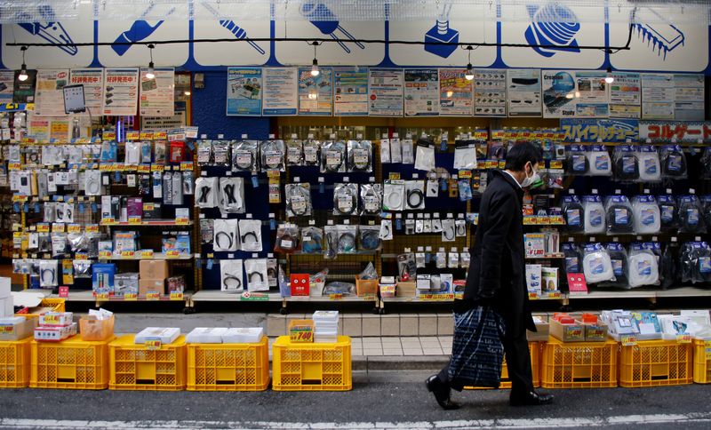 &copy; Reuters. FOTO DE ARCHIVO: Un hombre camina frente a una tienda de electrónica en Tokio
