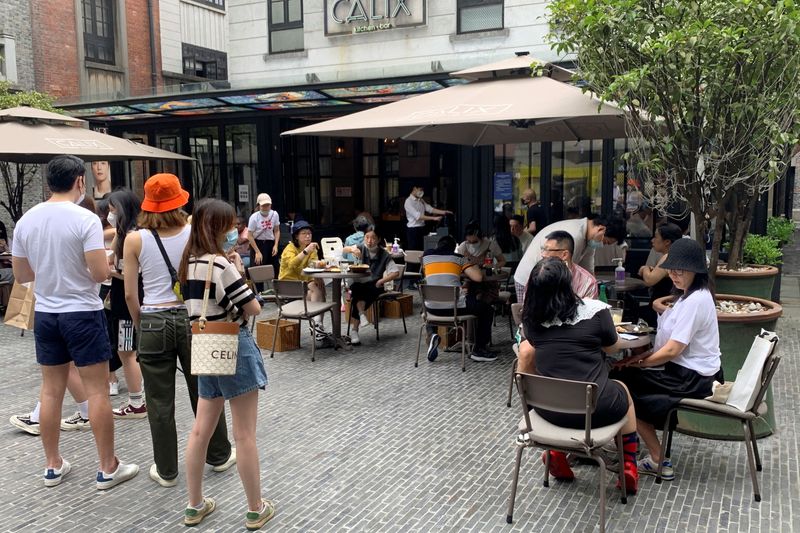 &copy; Reuters.  ６月２９日、 中国の上海市でレストランの店内での飲食が再開された。写真は３日、上海の飲食店のテラス席で食事する人々（２０２２年　ロイター/Xihao Jiang）