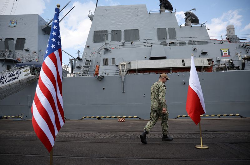 &copy; Reuters. Un miembro de la marina estadounidense camina entra la bandera de Estados Unidos y Polonia frente a un buque estadounidense en el puerto báltico de Gdynia, Polonia, el 7 de junio de 2022. REUTERS/Kacper Pempel/Files