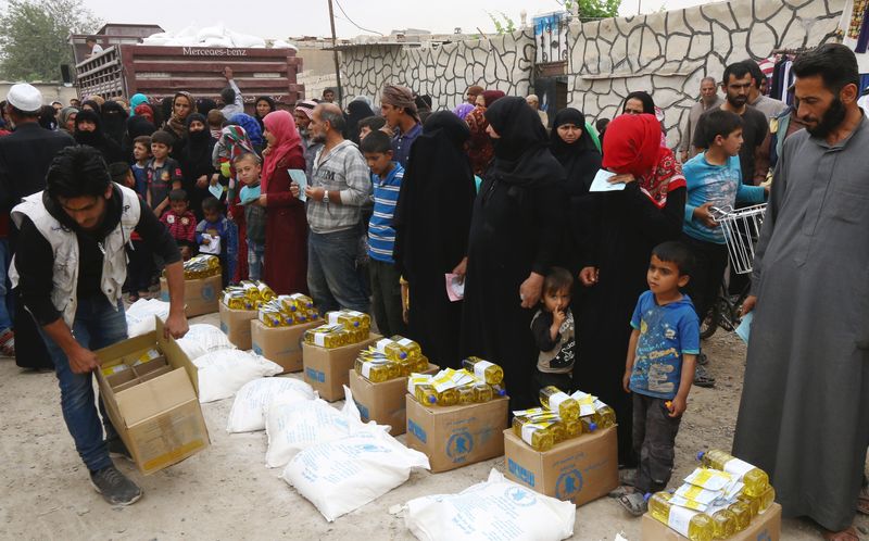 &copy; Reuters. أفراد يحصلون على معونات من برنامج الأغذية التابع للأمم المتحدة في الرقة بسوريا - صورة من أرشيف رويترز. 