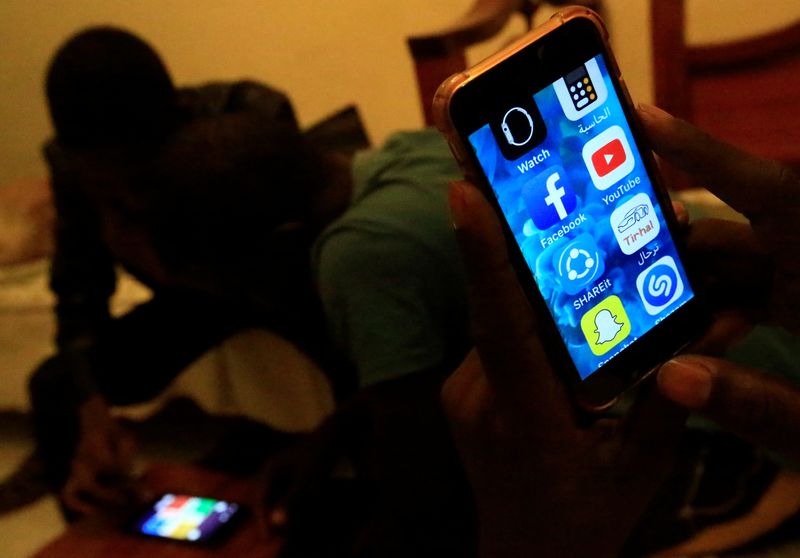 &copy; Reuters. سودانيون يحاولون استخدام هواتفهم المحمولة في ظل انقطاع خدمة الإنترنت بالخرطوم. صورة من أرشيف رويترز