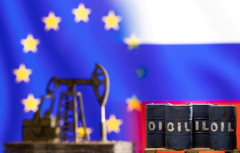 &copy; Reuters. Miniature di una pompa petrolifera e di barili di greggio davanti alle bandiere dell'Unione europea e della Russia. REUTERS/Dado Ruvic