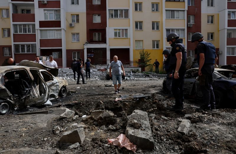 © Reuters. مدنيون وقوات دفاع مدني في موقع قصف روسي بمدينة خاركيف الأوكرانية يوم 26 يونيو حزيران 2022. رويترز