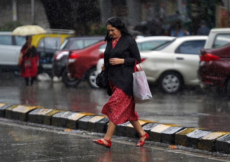 &copy; Reuters. Mulher atravessa rua durante chuva em Mumbai, na Índia. 
20/09/2019. 
REUTERS/Hemanshi Kamani