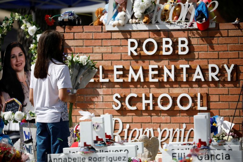 &copy; Reuters. A woman pays respects at the memorial at Robb Elementary school, where a gunman killed 19 children and two adults, in Uvalde, Texas, U.S. May 29, 2022. REUTERS/Marco Bello