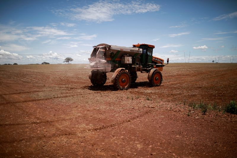 &copy; Reuters. FILE PHOTO: An agricultural worker drives a tractor spreading fertilizer in a soybean field, near Brasilia, Brazil February 15, 2022.  REUTERS/Adriano Machado/File Photo