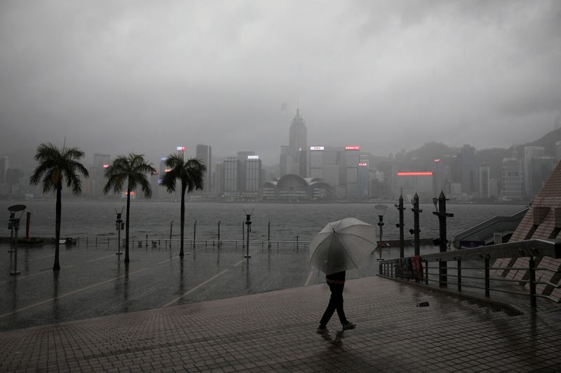 &copy; Reuters. شخص يمسك بمظلة لدى سيره تحت الأمطار عند الواجهة المائية في هونج كونج وسط تحذير من إعصار يوم الجمعة. تصوير باول يونج- رويترز.