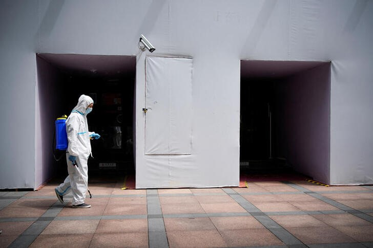 &copy; Reuters. 中国東部の複数都市が３日、新型コロナウイルスのクラスター（感染者集団）発生を受けて規制を強化した。写真は、上海市内で消毒作業にあたる男性の様子。２０２２年７月１日に撮影。