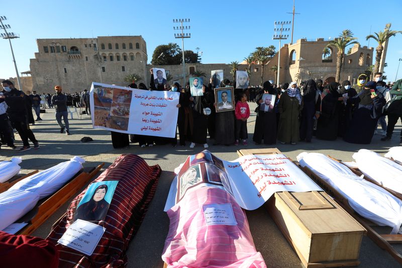 &copy; Reuters. جثث منتشلة من مقبرة جماعية في ترهونة بليبيا قبل إعادة دفنها في طرابلس وذوو الضحايا يحملون صورهم في 22 يناير كانون الثاني 2021. تصوير حازم أحمد-ر
