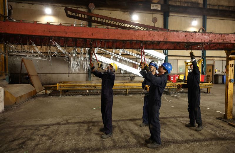 &copy; Reuters. Workers remove pieces of wire from a frame inside the factory of Corbetts The Galvanizers in Telford, Britain, June 28, 2022. REUTERS/Phil Noble