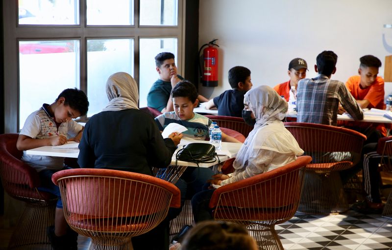 © Reuters. طلاب يستذكرون دروسهم داخل مطعم في طرابلس يوم 29 يونيو حزيران 2022. تصوير: حازم أحمد - رويترز .