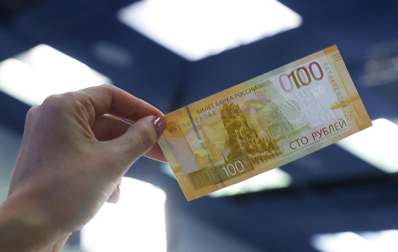 &copy; Reuters. FILE PHOTO: A person holds the newly designed Russian 100-rouble banknote during a presentation in Moscow, Russia June 30, 2022. REUTERS/Evgenia Novozhenina