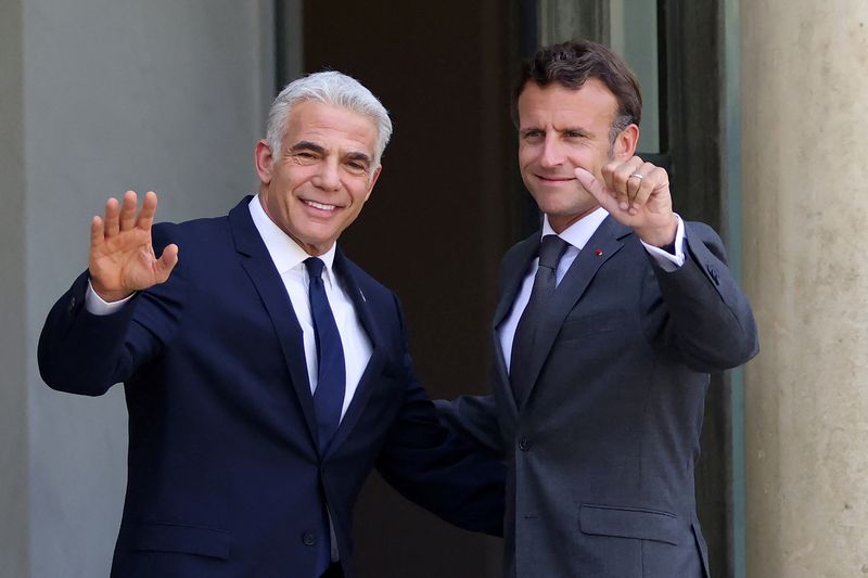 &copy; Reuters. رئيس الوزراء الإسرائيلي يائير لابيد (الى اليسار) والرئيس الفرنسي إيمانويل ماكرون في باريس يوم الثلاثاء. صورة لرويترز.