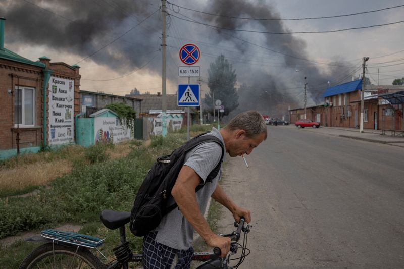 &copy; Reuters. Un homme pousse un vélo dans une rue devant le marché après un bombardement à Sloviansk, dans la région de Donetsk, en Ukraine. Les forces russes ont frappé mardi un marché et une zone d'habitation dans la ville de Sloviansk, tuant au moins deux pe