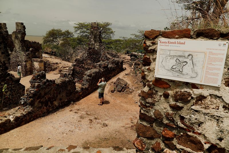 &copy; Reuters. FILE PHOTO: A tourist takes a photograph of ruins on the Kunta Kinte island in the Gambia River, Jufureh near Albreda, on the north bank of Gambia July 19, 2019.  REUTERS/Zohra Bensemra