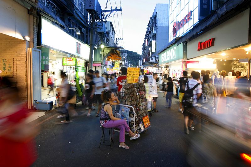 &copy; Reuters. FILE PHOTO: A woman sits beside her stall at the Shilin night market in Taipei July 15, 2008. REUTERS/Nicky Loh