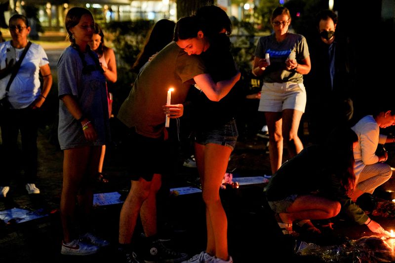 &copy; Reuters. Community members embrace at a memorial site near the parade route the day after a mass shooting at a Fourth of July parade in the Chicago suburb of Highland Park, Illinois, U.S. July 5, 2022.  REUTERS/Cheney Orr  REFILE - QUALITY REPEAT