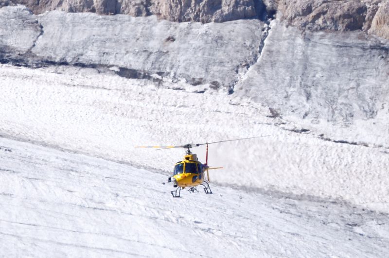 &copy; Reuters. A helicopter participates in a search and rescue operation over the site of a deadly collapse of parts of a mountain glacier in the Italian Alps amid record temperatures, at Marmolada ridge, Italy July 6, 2022. REUTERS/Guglielmo Mangiapane  ?