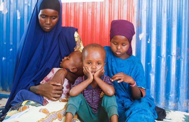 &copy; Reuters. Amina Hassan Aden ao lado de seus filhos Yonis Saleban, de 1 ano, Abdulahi Saleban,  de 3, e Isnino Saleban, de 9, dentro de barraca improvisada no acampamento para deslocados internos de Kaxareey em Dollow, na região somali de Gedo 
24/05/2022 REUTERS/F