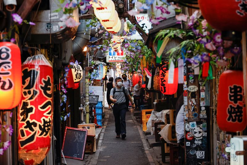 &copy; Reuters. People wearing protective masks walk at a Japanese Izakaya pub alley, amid the coronavirus disease (COVID-19) outbreak, in Tokyo, Japan July 6, 2022.  REUTERS/Issei Kato