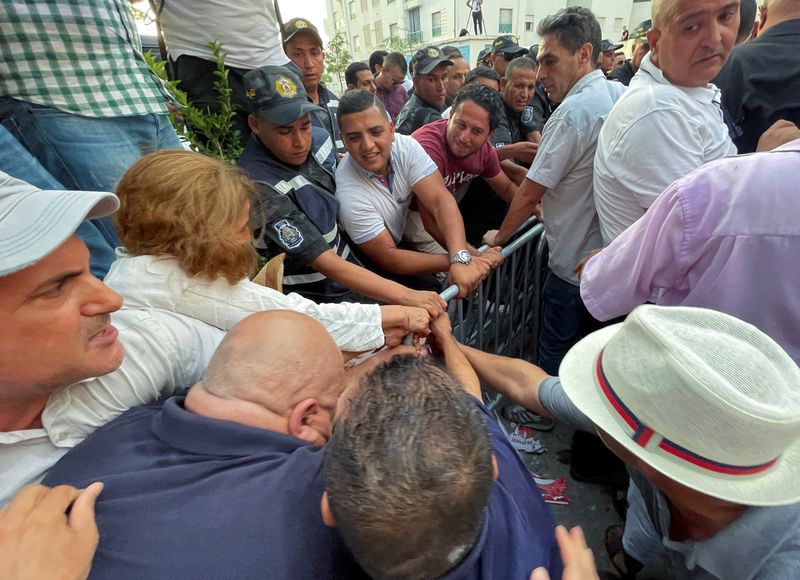 &copy; Reuters. متظاهرون تونسيون يحاولون ازاحة الحواجز من أجل الوصول إلى مكاتب اللجنة الانتخابية في تونس العاصمة يوم الخميس. صورة لرويترز. 