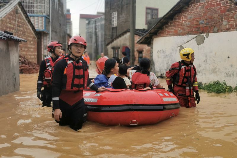 &copy; Reuters.   ７月８日、中国政府は今年の豪雨シーズンのピークを前に全土に災害への備えを呼び掛けた。写真は４日、大雨で浸水した北海市で住民を避難させる救助関係者（２０２２年　ロイター/cns