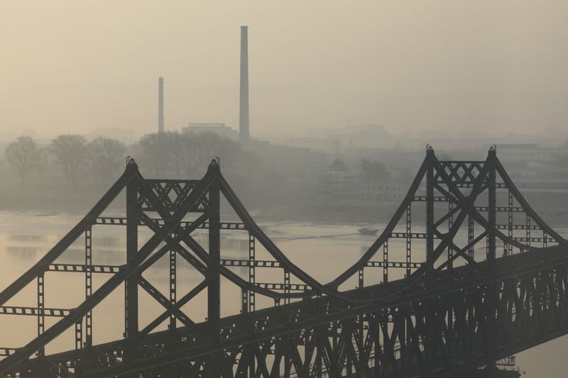 &copy; Reuters. FOTO DE ARCHIVO. Edificios en Sinuiju de Corea del Norte detrás del Puente de la Amistad sobre el río Yalu, durante el amanecer en Dandong, provincia de Liaoning, China. 20 de abril de 2021. REUTERS/Tingshu Wang
