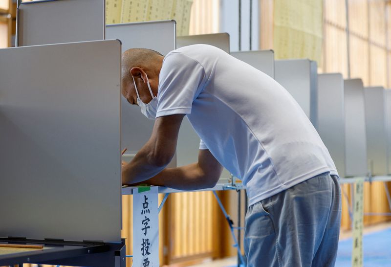 &copy; Reuters. ناخب يستعد للإدلاء بصوته في انتخابات مجلس المستشارين في مركز اقتراع بطوكيو يوم الأحد. تصوير: إيسي كاتو - رويترز