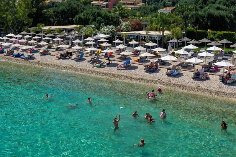 &copy; Reuters. FILE PHOTO: People enjoy the sea at Barbati beach on the island of Corfu, Greece, June 30, 2022. REUTERS/Adonis Skordilis